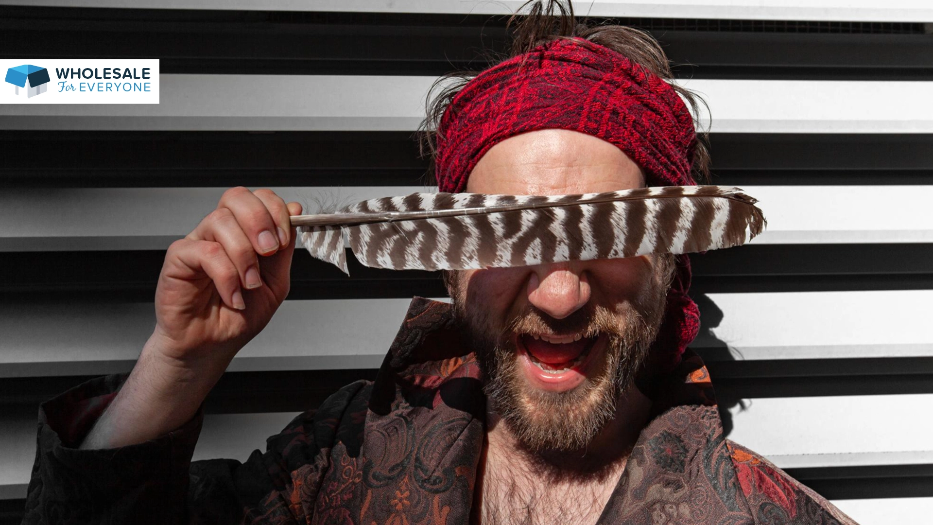The photo shows a man wearing a pirate costume and holding a feather to cover his eyes.