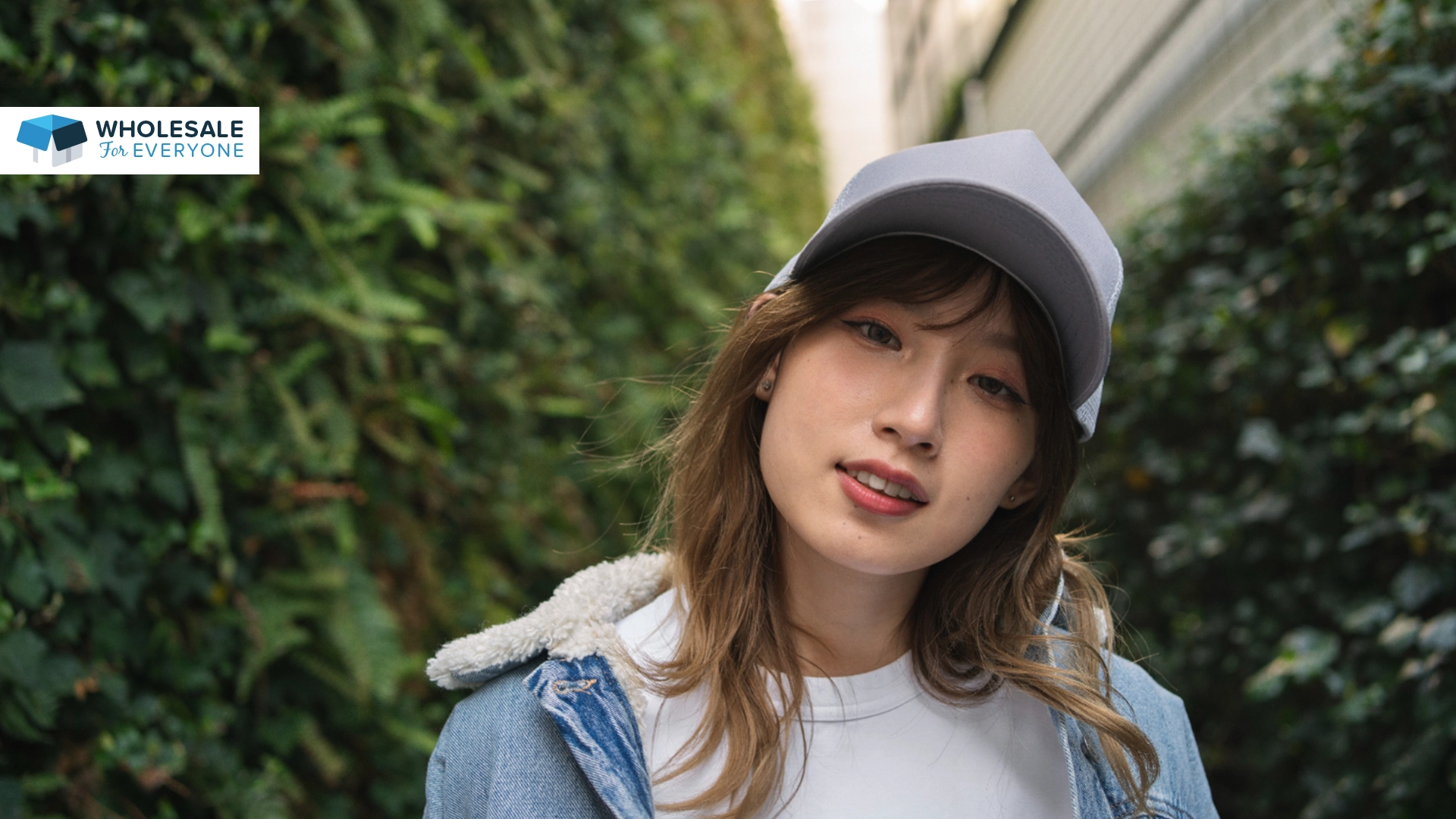 The photo shows a lady wearing a jacket and a baseball cap.