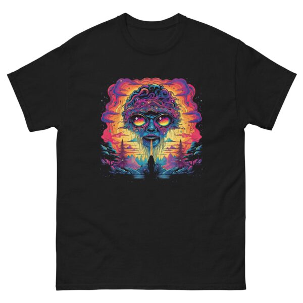 A colorful graphic of an alien face with large eyes and dripping mouth dominates a black shirt design  set against a vibrant sunset with trees and clouds in the background.