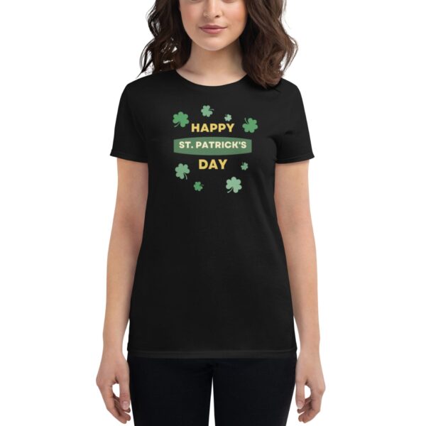 A woman wears a black t-shirt displaying the text "HAPPY ST. PATRICK'S DAY" surrounded by green shamrocks in a festive context suitable for St. Patrick's Day celebrations.