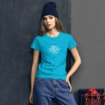 A young woman stands against a textured dark wall wearing a bright turquoise t-shirt with the text Happy St Patrick's Day and a dark beanie with casual blue jeans