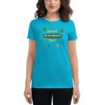 A woman is wearing a bright turquoise shirt with the text "HAPPY ST. PATRICK'S DAY" surrounded by green shamrocks  celebrating St. Patrick's Day in a festive context.