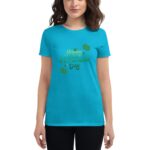 A woman is wearing a bright blue t-shirt featuring a festive graphic that reads "Happy St. Patrick's Day" in green font surrounded by decorative elements suitable for the holiday.