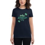 A person wears a navy t-shirt featuring the text "Happy St. Patrick's Day" in green with decorative elements  celebrating the holiday in a casual setting.
