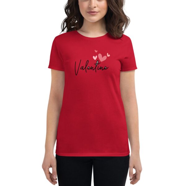 A red t-shirt features the word "Valentine" in a stylish font with small hearts above it  worn by a person standing against a neutral background.