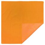 A square orange cloth is laid flat with one corner folded over revealing a lighter orange underside in a neutral setting.