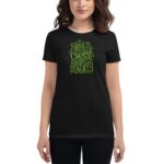 A woman is wearing a black t-shirt featuring green text that reads you have the courage to begin again happy st patricks 2023 against a neutral background.