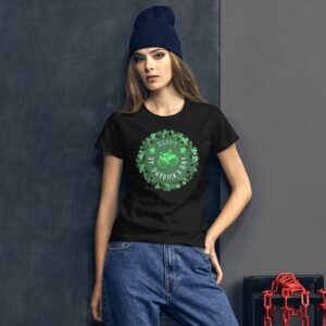 A woman is wearing a black t-shirt with a green graphic that says "Happy St. Patrick's Day" surrounded by shamrocks in front of a textured dark background.