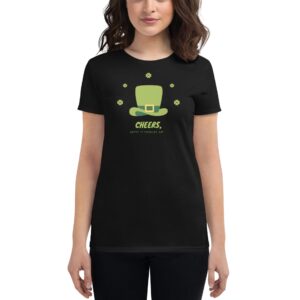 A person wears a black t-shirt featuring a green leprechaun hat graphic with text that says Cheers and Happy St. Patrick's Day surrounded by small shamrocks.