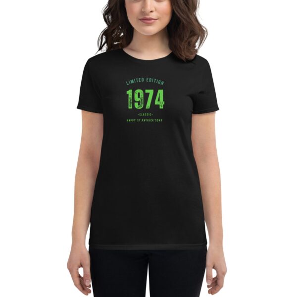 A black t-shirt with green text reads LIMITED EDITION 1974 CLASSIC HAPPY ST PATRICK'S DAY worn by a woman with shoulder-length wavy hair in a neutral setting.
