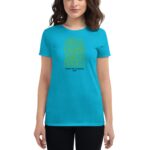 A woman wearing a bright turquoise t-shirt displaying intricate yellow text that reads you have the courage to begin again along with the words happy st. patricks 2024.