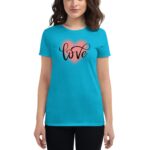A woman wears a bright blue t-shirt featuring the word "love" in elegant black cursive  overlaid on a subtle pink heart  set against a plain background.