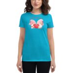 A turquoise t-shirt features a graphic of two gnome-like characters holding a red heart with the word love while surrounded by decorative hearts and text above them expressing affectionate sentiment.
