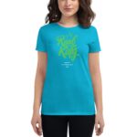 A woman is wearing a bright blue t-shirt featuring green stylized text that reads "Real King" with a crown above it and "Happy St. Patrick's Day" below.