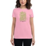 A woman is wearing a light pink t-shirt with a vibrant green decorative text design stating You have the courage to begin again and Happy St. Patricks 2024 on it.