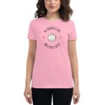 A woman wearing a pink t-shirt with a cute coffee cup design featuring a smiling face and text that reads ALL YOU NEED IS LOVE AND A CUP OF COFFEE surrounded by hearts