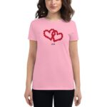 A person wearing a pink t-shirt displays a design of two intertwined hearts made of red flowers with the number 2024 below them in black against a plain background.