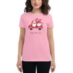 A pink t-shirt features a cartoon red car with two gnomes inside surrounded by hearts and the text Happy Valentine’s Day below the car design.