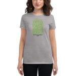 A woman wears a gray t-shirt featuring green text that reads You have the courage to begin again Happy St. Patricks 2024  smiling against a neutral background.