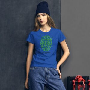 A person wears a blue shirt with green text that reads every journey needs a first step happy st patricks 2022 against a dark textured background with chains visible.