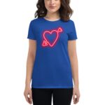 A woman wears a bright blue t-shirt featuring a glowing red heart design with an arrow. She stands against a plain white background  presenting a casual and stylish appearance.