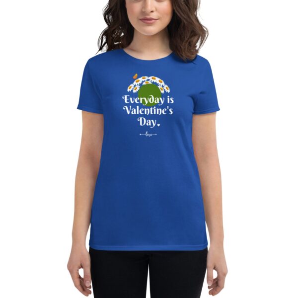 A woman wears a bright blue t-shirt featuring the text "Everyday is Valentine's Day" decorated with flowers and a butterfly in a casual setting.