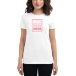 A woman wears a white t-shirt featuring a graphic design of a stamp with repeated "XOXO" in pink and grey colors against a plain background.