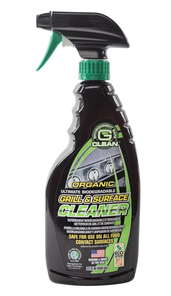 A spray bottle containing a biodegradable grill and surface cleaner is positioned upright it features a black nozzle with a green trigger and green details on the label highlighting its safety and eco-friendliness.
