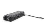 A small black electronic device with buttons labeled ON Light Train and Chaser is positioned at a slight angle It features a speaker grille at one end and a wrist strap attached