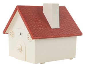 A small plastic house toy features a red sloped roof and a chimney showcasing circular windows and a door with a knob resembling a miniature playhouse design.