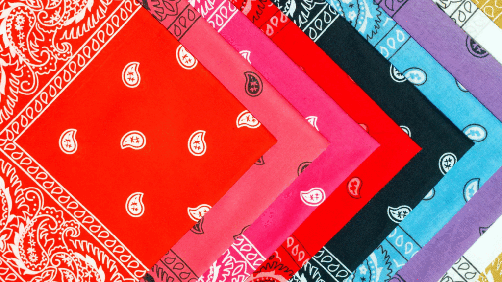 landscape-oriented image showing stacks of colorful bandanas arranged side by side in a diamond layout, showcasing various colors and classic paisley patterns.
