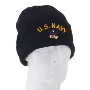 A black beanie hat displays "U.S. NAVY" in yellow lettering and features an embroidered emblem. It sits on a white mannequin head against a plain background.