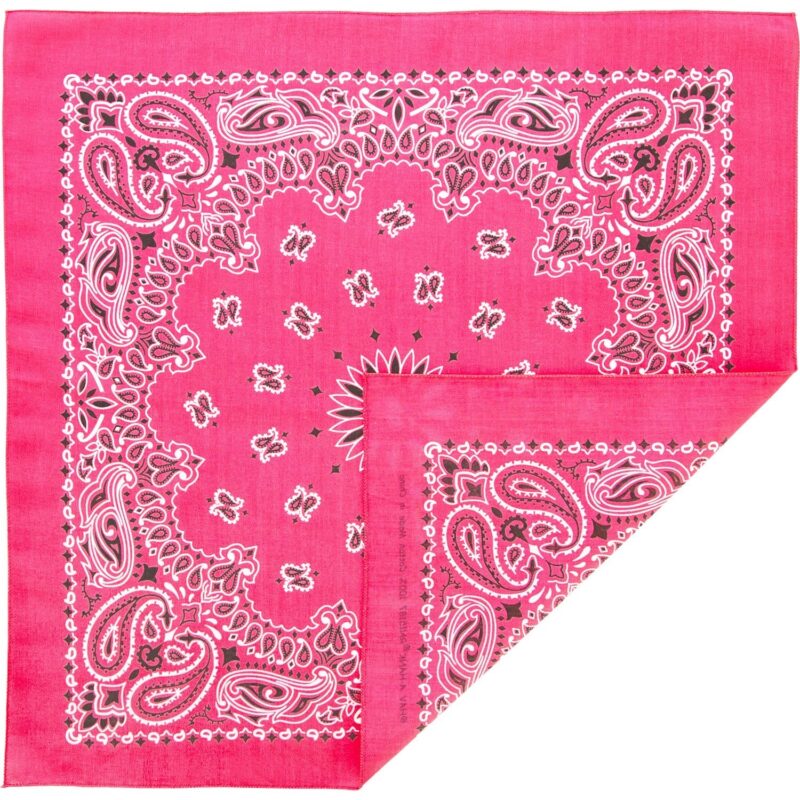 A pink bandana with intricate white and black paisley patterns is partially folded revealing a corner and showcasing its vibrant color and detailed design against a plain background.