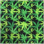 A patterned cloth displays vibrant green cannabis leaves against a solid black background creating a striking contrast and an eye-catching design suitable for various decorative uses.
