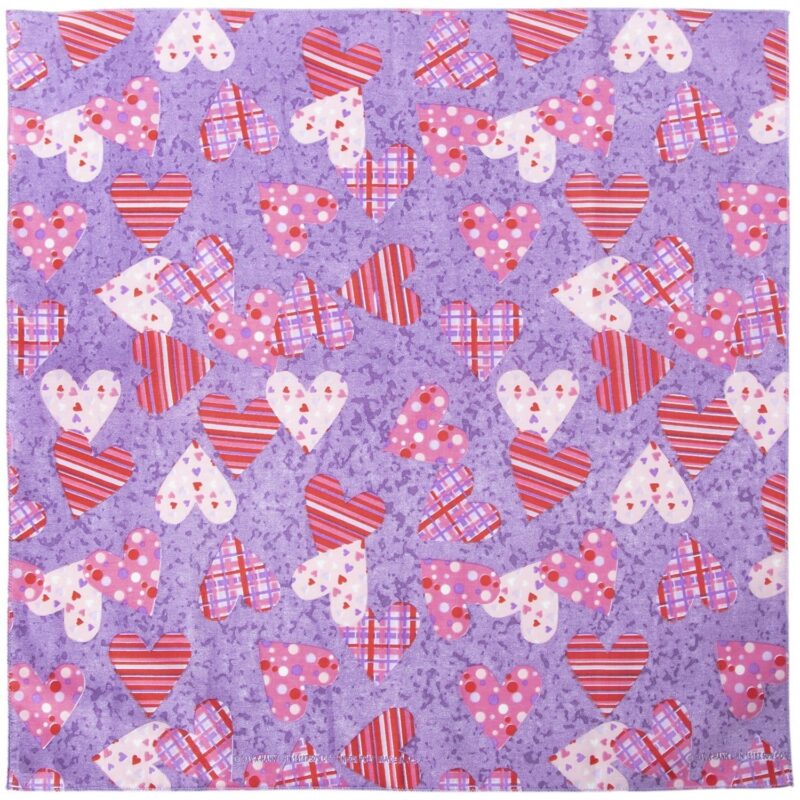 A purple fabric showcases a scattered pattern of various hearts in red and pink shades featuring stripes polka dots and plaid designs creating a playful decorative theme.