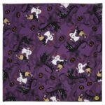 A purple fabric displays a repeated pattern of ghosts  cats  bats  pumpkins  and witches against a whimsical Halloween-themed backdrop  creating a festive atmosphere.