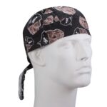 A black bandana patterned with pirate skulls and hats adorns a white mannequin head facing right in a neutral background showcasing the design clearly.