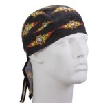 A black bandana with yellow and red flame patterns and a white cross is worn on a mannequin's head in a neutral setting. The bandana ties at the back.