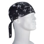 A black bandana is worn on a white mannequin head featuring white skull and crossbones designs the bandana is tied at the back with two hanging ends