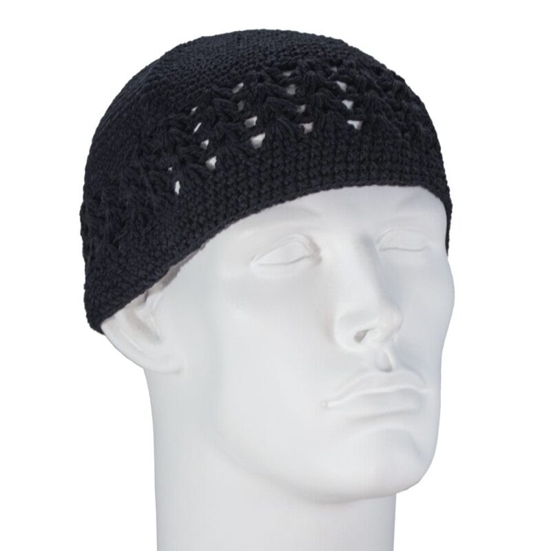 A black crocheted cap sits snugly on a plain white mannequin head facing slightly to the side in a neutral setting highlighting the cap’s intricate pattern and texture.