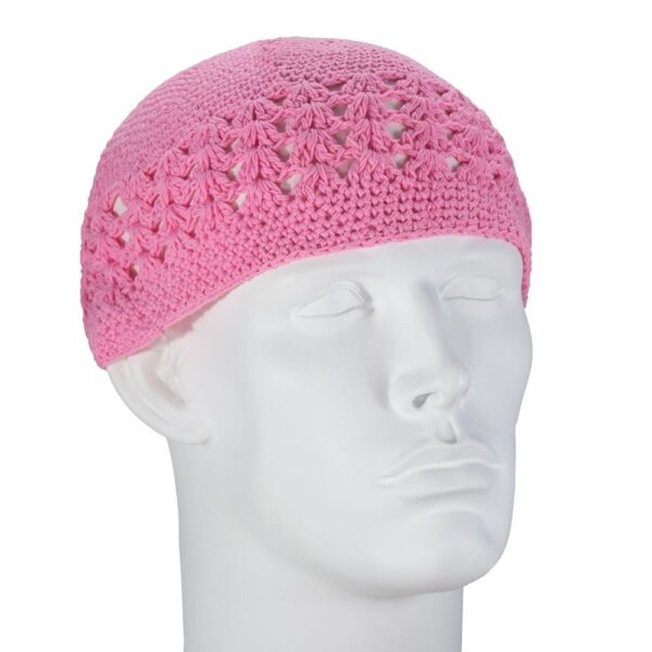 A light pink crocheted cap rests on a white mannequin head showcasing interwoven patterns creating an airy design suitable for warmth while allowing airflow in a neutral  plain setting.