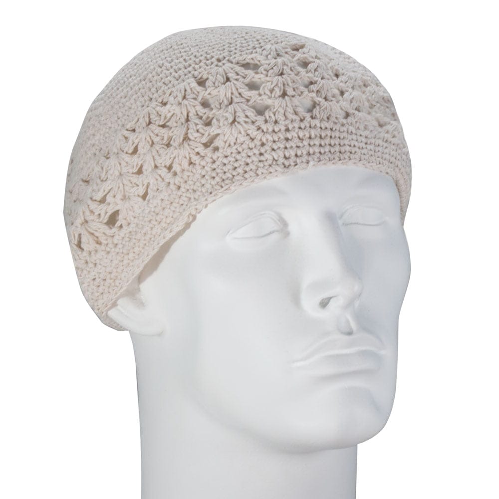 A white crocheted beanie rests on a plain white mannequin head facing slightly upward in a neutral setting showcasing its textured design and round shape.
